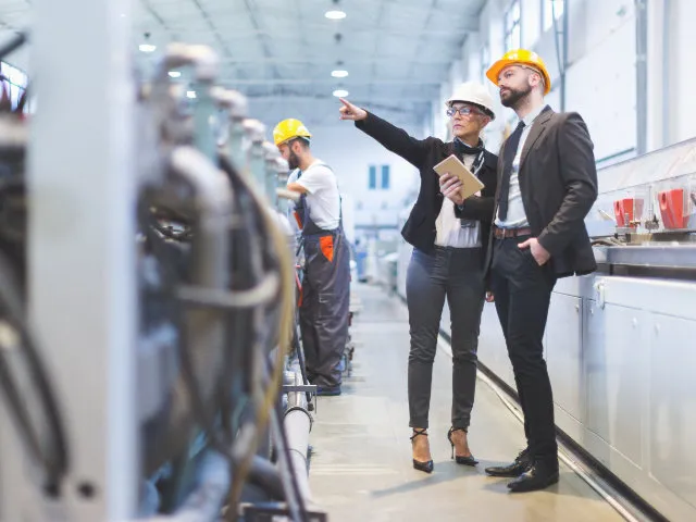 People in manufacturing facility wearing hard hats