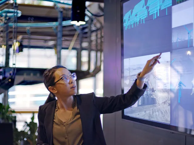 Person presenting data and charts on a large screen